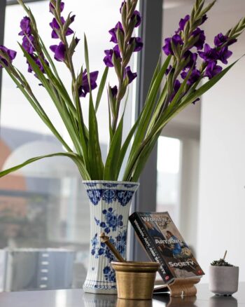 A Delft Blue flower vase with an old mortar and an artbook on kitchen
